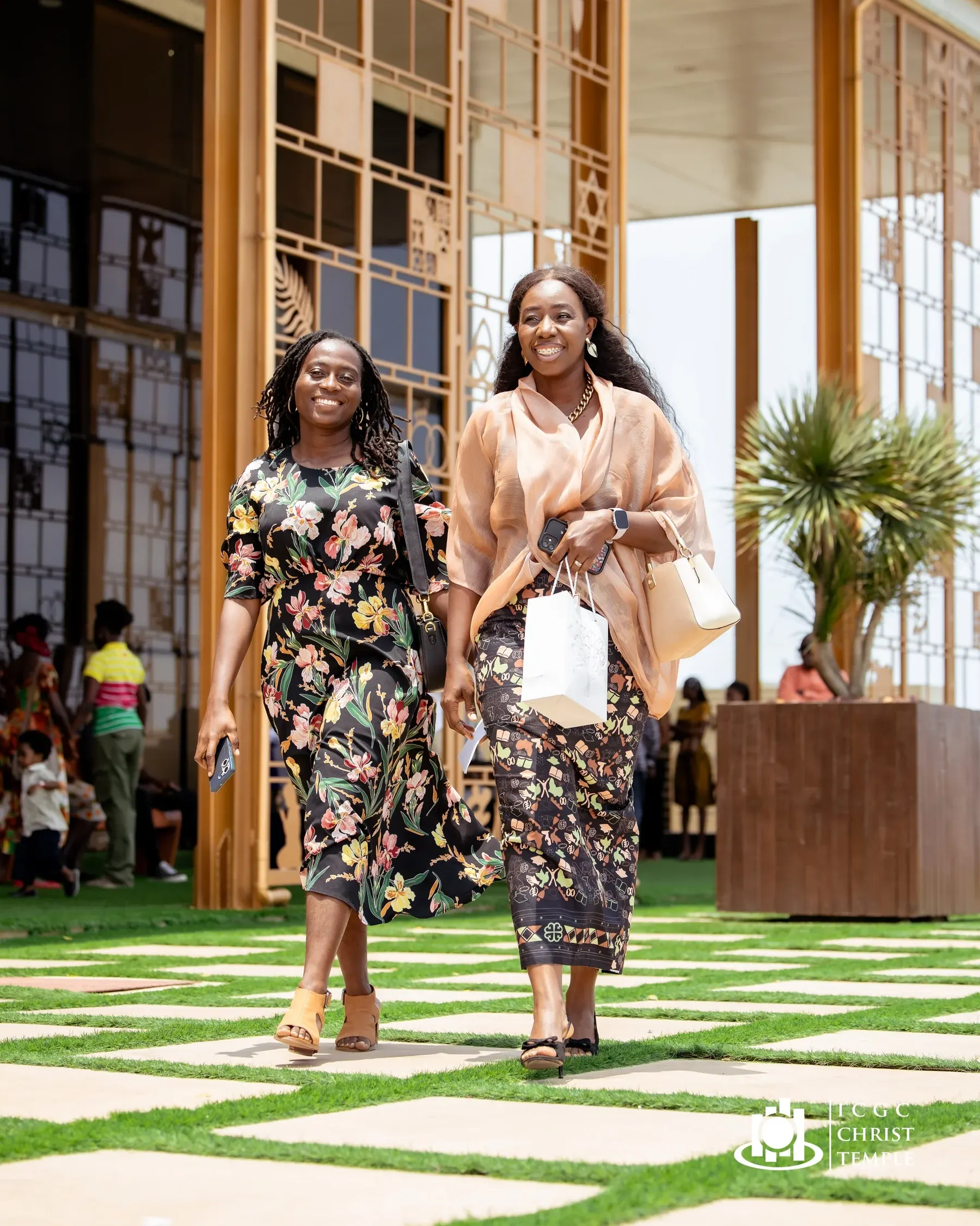 Two women arriving at Christ Temple in colourful Sunday clothing